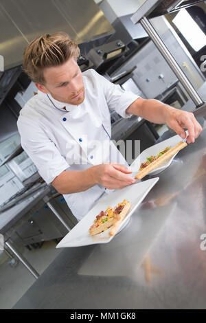 Koch, das Essen auf dem Teller Stockfoto