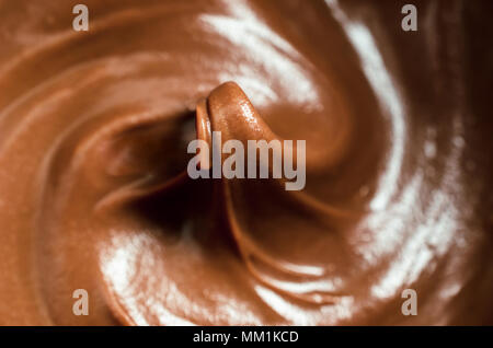 Close Up (Makro) von melting Milchschokolade, gerührt in wirbelt mit steigenden Peak in der Mitte des Rahmens. Geringe Tiefenschärfe. Stockfoto