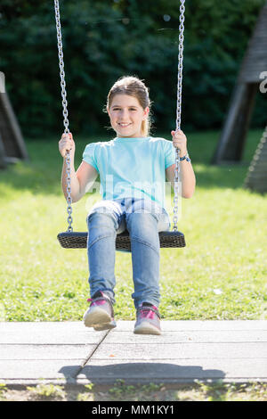 Kid in swingtime am Abenteuerspielplatz Stockfoto