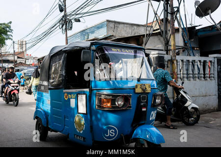 Blau Auto-rikscha auf einem engen und überfüllten Straße in einem armen Dorf in Indonesien Stockfoto