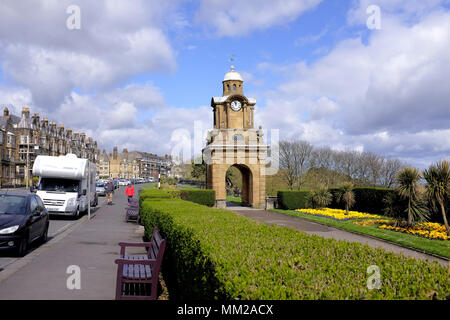 Scarborough, Yorkshire, UK. April 25, 2018. Urlauber zu Fuß die Esplanade Vergangenheit der Holbeck Glockenturm und den South Cliff Gärten in Scarboro Stockfoto