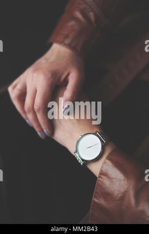 Frau silber Armbanduhr und braunem Leder Mantel. Nahaufnahme der Hände von oben Stockfoto