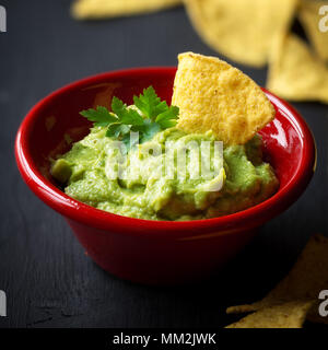 Guacamole Dip zu Nachos oder Tortilla Chips Stockfoto