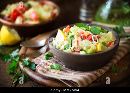 Vegetarische tabbouleh - lecker couscous Salat mit Tomaten, Gurken, frischer Minze und Petersilie. Stockfoto