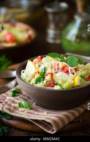 Vegetarische tabbouleh - lecker couscous Salat mit Tomaten, Gurken, frischer Minze und Petersilie. Stockfoto