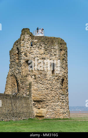 Ruinen der Burg Feuerstein am Fluss Dee in Flintshire, North Wales. Touristen auf der North East Tower mit Blick auf die Flussmündung. Stockfoto