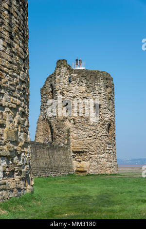 Ruinen der Burg Feuerstein am Fluss Dee in Flintshire, North Wales. Touristen auf der North East Tower mit Blick auf die Flussmündung. Stockfoto