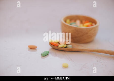 Verschiedene pharmazeutische Medizin Pillen, Tabletten und Kapseln auf hölzerne Schüssel Stockfoto