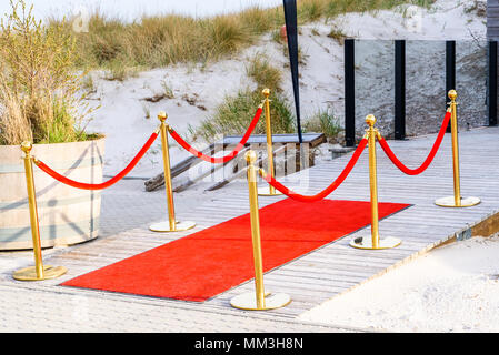 Skanor, Schweden - Roter Teppich auf einer hölzernen outdoor Rampe mit Dünen im Hintergrund. Stockfoto