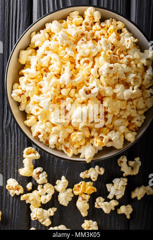 Beliebter Snack: gesalzene Popcorn mit Cheddar Käse und Parmesan in eine Schüssel close-up auf den Tisch. Vertikal oben Ansicht von oben Stockfoto