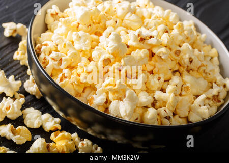 Hausgemachte gesalzenem Popcorn mit Käse Cheddar und Parmesan in eine Schüssel close-up auf dem Tisch. Horizontale Stockfoto