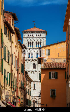 Blick auf Lucca Altstadt mit St. Michael in Foro mittelalterlichen Glockenturm von Stadt engen Straße aus gesehen Stockfoto