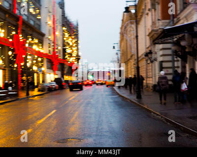 Weihnachtsbeleuchtung, Weihnachtsschmuck auf der Straße. verschwommenen Hintergrund Stadt Straße mit Weihnachtsbeleuchtung. Autos auf der Straße Stockfoto