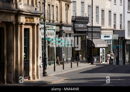 Geschäfte und Bars und Restaurants in Montpellier, Cheltenham. Zwei Fußgänger in der Ferne. Stockfoto