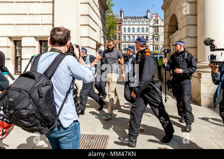 Die Metropolitan Police Officers escort Prominente muslimische Sprecher Muhammed Hijab entfernt von einer Freiheit der Rede Rally, London, UK Stockfoto