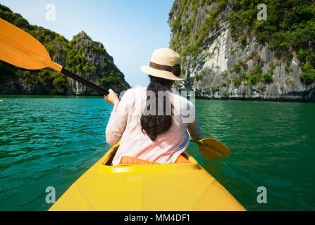 Mädchen, Kajakfahren auf dem Meer der Halong-Bucht in Vietnam Stockfoto