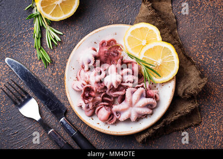 Tintenfische in der Platte mit Zitrone und Rosmarin Stockfoto