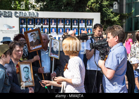 REGION Kursk, Russland - Mai 9, 2018. Menschen nehmen an der Parade des Unsterblichen Regiment mit Porträts ihrer Verwandten, die Parti Stockfoto