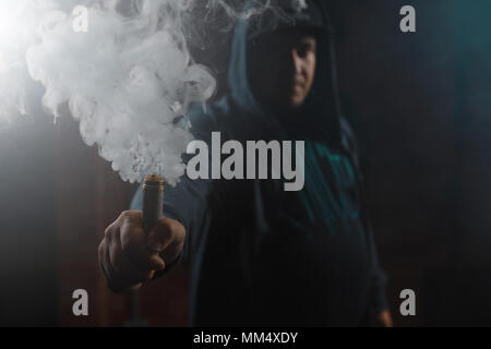 Tropfer in einer Hand eine Wolke aus weißen, blauen Dämpfen. Freundlich für vape shop Poster und Design. Vaping Konzept. Stockfoto