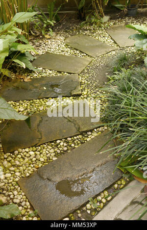 Steinplatten und kleinere Brocken, die man in einem Garten Stockfoto