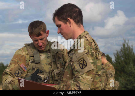 US Army Lieutenant Adam Kunkle (rechts), der Zugführer des 3 Platoon, Firma B, 3-10 Allgemeine Unterstützung Aviation Battalion, 10 Combat Aviation Brigade, 10 Mountain Division, und Staff Sgt. Neil McCrea, der platoon Sergeant für 2 Platoon, Firma B, 3-10 GSAB, gehen über den Bereich Layout während einer Antenne schießwesen Tabelle Adazi, Lettland am 8. September 2017. Die Aktivitäten waren Teil der amerikanischen Truppen Ausbildung in Lettland während der Atlantischen lösen, eine NATO-Mission zwischen den USA und ihren europäischen Verbündeten und Partnern, um den Frieden zu fördern und die regionale Stabilität in Osteuropa sicher Stockfoto