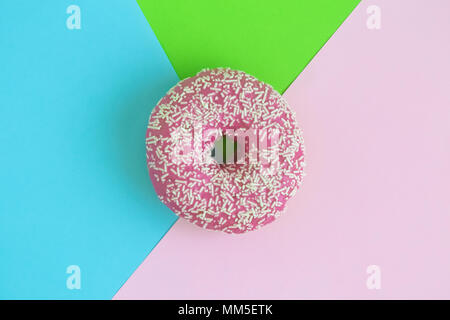Lecker rosa Donut auf farbenfrohen Pastelltönen Hintergrund minimal kreatives Konzept isoliert. Stockfoto