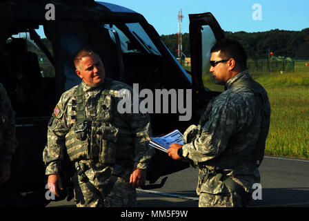 Army Chief Warrant Officer 3 Matt Quackenbush, rechts, bietet eine flugzeugbesatzung briefing Maj. Paul Bailie als Besatzungen, der New York Army National Guard Firma A, 3 Bataillon, 142 Aviation Regiment Vorbereitung für den Start und die Bereitstellung von Albany International Airport in Latham, New York nach Florida zur Unterstützung der Guard Reaktion auf den Hurrikan Irma September 11, 2017. 10 UH-60 Blackhawk Hubschrauber und 55 Aircrew Mitglieder und Betreuer von drei Flug Einrichtungen durch den Staat bereitgestellt die Florida Army National Guard zu unterstützen. Us National Guard Fotos von Oberst Richard Goldenberg. Stockfoto