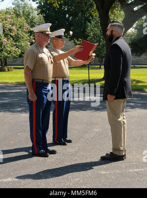 SAN ANTONIO (Sept. 8, 2017) Sgt. Maj. Max Garcia, Center, 3D-Assault Amphibian Bataillon in Camp Pendleton, Kalifornien, liest eine Auszeichnung Zitat zum Marine Corps veteran Corporal Randy D. Mann, rechts, während Oberstleutnant William O'Brien, kommandierender Offizier steht an Aufmerksamkeit während einer Zeremonie im historischen Viereck am Joint Base San Antonio - Fort Sam Houston, Texas. Mann war die Navy und Marine Corps Medaille während der Zeremonie in seiner Heimatstadt San Antonio für seine Taten vergeben, während im aktiven Dienst mit der 3D-Assault Amphibian Bataillon im Juli 2013. (U.S. Marine Foto von Masse Kommu Stockfoto