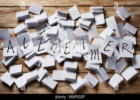 Ein Stapel von Papier in der Hälfte gefaltet, und der Text text Alzheimer in einigen von ihnen entfaltet auf der Oberseite Stockfoto