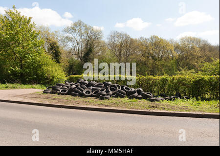 Beschämend Schuttplatz vieler Autoreifen neben einem Feldweg in Kent, direkt an einer Hauptstraße, Alte Terry's Lodge Road, Kemsing Stockfoto