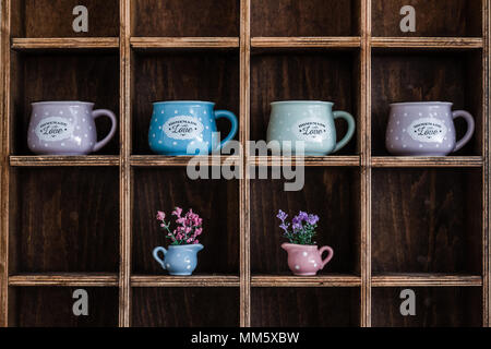 Keramik Kaffeetassen auf handgefertigten Holzmöbeln rustikal Wandregal Stockfoto