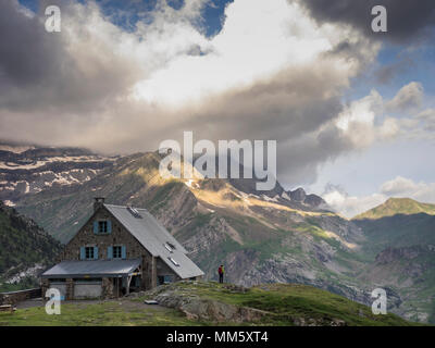 Frau Wandern in den Pyrenäen auf einem kleinen Felsen neben Zuflucht des Espuguettes, Gavarnie, Frankreich Stockfoto