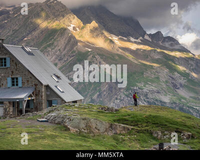 Frau Wandern in den Pyrenäen auf einem kleinen Felsen neben Zuflucht des Espuguettes, Gavarnie, Frankreich Stockfoto