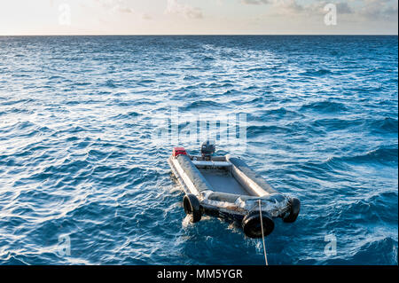 Ein kleines Beiboot Bobs auf dem Wasser hinter dem Leben an Bord tauchen Boot auf dem Great Barrier Reef Queensland Australien. Stockfoto