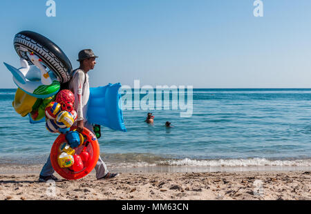 Hausierer Arbeiten am Strand im Sommer mit aufblasbaren Spielen Stockfoto