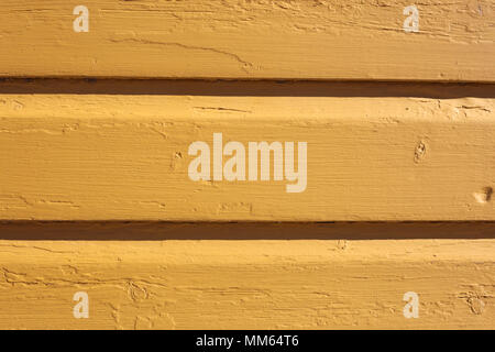 Eine Nahaufnahme eines von außen eine Holzwand mit einige horizontale Linien und rissige alte Farbe. Stockfoto