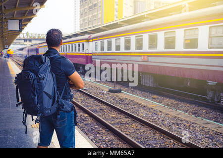 Männer Backpacker wartet auf seinen Zug im Bahnhof. Stockfoto