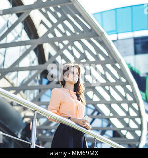 Erfolgreiche Geschäftsfrau steht auf dem Balkon des modernen Büro- und in die Ferne schaut. Stockfoto