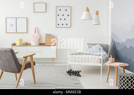 Süße Kissen auf Metallrahmen ein Kinderbett und einfachen Holzmöbeln in einem kreativen Design Schlafzimmer für ein junges Mädchen Stockfoto