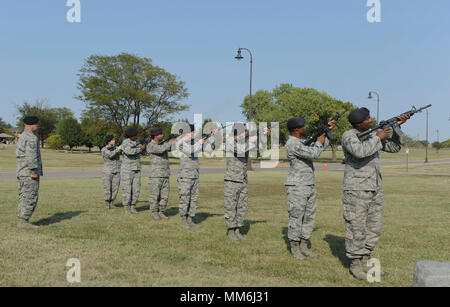 Verteidiger der 22 Sicherheitskräfte Squadron machen drei - volley Salute während der Patriot Tag retreat Zeremonie Sept. 11, 2017 zugeordnet, McConnell Air Force Base, Kansas. Die Zeremonie 9/11 Ersthelfer geehrt. (U.S. Air Force Foto: Staff Sgt. Rahel Waller) Stockfoto