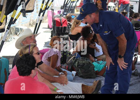 Cmdr. Tim Cronin, kommandierender Offizier, Coast Guard Cutter Valiant, Gespräche mit einigen der Umsiedler von St. Thomas, U.S. Virgin Islands, die an Bord der Cutter Dienstag geholt wurden, Sept. 12, 2017. Das Patrouillenboot Valiant crew transportiert 78 Erwachsene, 21 Kinder und 13 Haustiere aus St. Thomas zu dem Cutter und übertragen sie zu den Norwegischen Himmel Kreuzfahrtschiff, wo Sie nach Puerto Rico transportiert werden. U.S. Coast Guard Foto/Video mit freundlicher Genehmigung von Stockfoto
