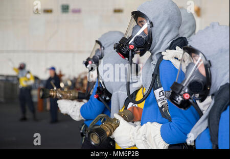 NORFOLK, Virginia (Sept. 12, 2017) - - USS Gerald R. Ford (CVN 78) Segler zugeordnet, Abteilung einen simulierten Brand während ein General Quarters bohren kämpfen. General Quarters Bohrer sind so ausgelegt, dass die Seeleute im Falle eines tatsächlichen Unfall an Bord des Schiffes zu trainieren. (U.S. Marine Foto von Mass Communication Specialist 3. Klasse Cathrine Mae O. Campbell) Stockfoto