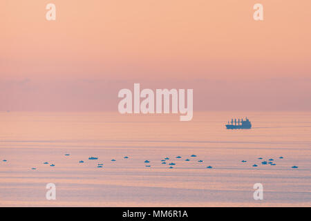 Große Frachter Schiff und kleinen Fischen Schiffe Stockfoto