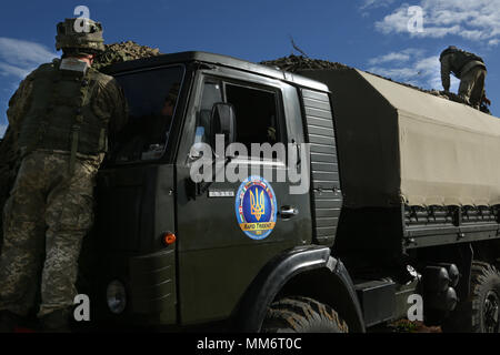 Ukrainische Soldaten der 1./30. mechanisierten Infanteriebataillon Ort camouflage Netting auf ihre Fahrzeuge während der Übung Rapid Trident 17 an der internationalen Friedenssicherung Security Center in Yavoriv, Ukraine Sept. 14, 2017. Schnelle Trident 17 teilnehmenden Nationen mit der Gelegenheit theater Sicherheit Zusammenarbeit in Osteuropa zu verbessern, die Interoperabilität zwischen NATO-Mitgliedern und Partnern zu verbessern und die Fähigkeiten zu kombinieren, gemeinsame, multinationale und integrierte Security Operations zu betreiben. (U.S. Armee Foto von Pfc. Zachery Perkins) Stockfoto