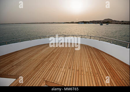 Blick über den Bug eines großen Luxus Motoryacht auf tropischen Meer bei Sonnenuntergang Stockfoto