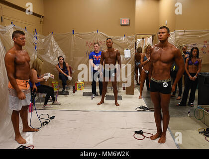 Senior Airman Paul Dell, 319 Logistik Bereitschaft Squadron Fahrer gesellen, steht an Aufmerksamkeit wie die Nationalhymne spielt vor einer Bodybuilding Wettkampf Sept. 9, 2017, in Rochester, Minnesota. Während die meisten Wettbewerber weiterhin die Vorbereitung für den Wettbewerb, Dell, als einzige militärische Mitglied instinctually kam die Aufmerksamkeit der Nationalhymne zu ehren. (U.S. Air Force Foto von älteren Flieger Ryan Funken) Stockfoto