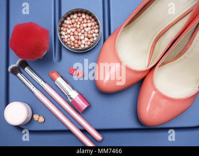 Frauen Schuhe und Make-up Accessoires in warmen Pastelltönen beige Farbe auf einem blauen Hintergrund. Konzept der weiblichen Schönheit und Ferienhäuser. Stockfoto