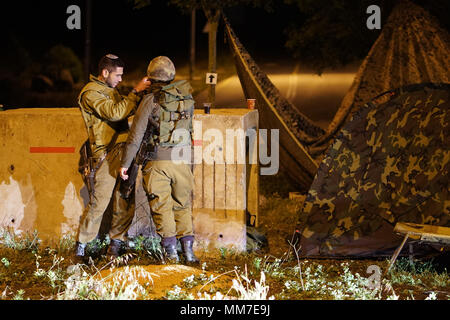 Golanhöhen, Syrien. 10. Mai, 2018. Israelische Soldaten guard eine Straße in der Israelischen - beigefügten Golanhöhen am 10. Mai 2018. Etwa 20 Raketen auf israelische Militärbasen durch iranische Truppen im südlichen Syrien am Mittwoch gefeuert wurden über Nacht und einige wurden von der israelischen Iron Dome Abwehr abgefangen, sagte, die israelische Armee. Credit: Jini/Xinhua/Alamy leben Nachrichten Stockfoto