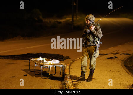 Golanhöhen, Syrien. 10. Mai, 2018. Ein israelischer Soldat bewacht eine Straße in der Israelischen - beigefügten Golanhöhen am 10. Mai 2018. Etwa 20 Raketen auf israelische Militärbasen durch iranische Truppen im südlichen Syrien am Mittwoch gefeuert wurden über Nacht und einige wurden von der israelischen Iron Dome Abwehr abgefangen, sagte, die israelische Armee. Credit: Jini/Xinhua/Alamy leben Nachrichten Stockfoto