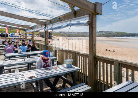 Urlauber entspannen auf der Terrasse des Fistral Beach Bar mit Blick auf den Fistral Beach in Newquay Cornwall. Stockfoto